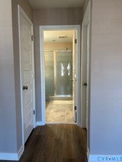 Four-panel interior doors, wood-finish flooring, and a walk-in shower enclosure with a glass door and tiled surround