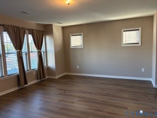 Spacious interior featuring wood-finish flooring, neutral wall tones, multi-pane windows, and inset ceiling lighting