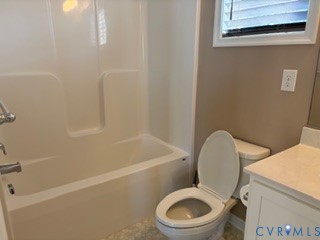 Bathroom featuring a tub-and-shower combination with a molded surround, a white vanity with a solid-surface countertop, and a window with horizontal blinds