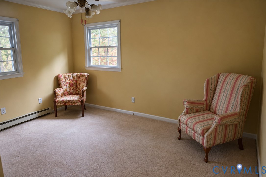 Room featuring neutral carpeting, double-hung windows, and a multi-light ceiling fixture Room featuring neutral carpeting, double-hung windows, and a multi-light ceiling fixture