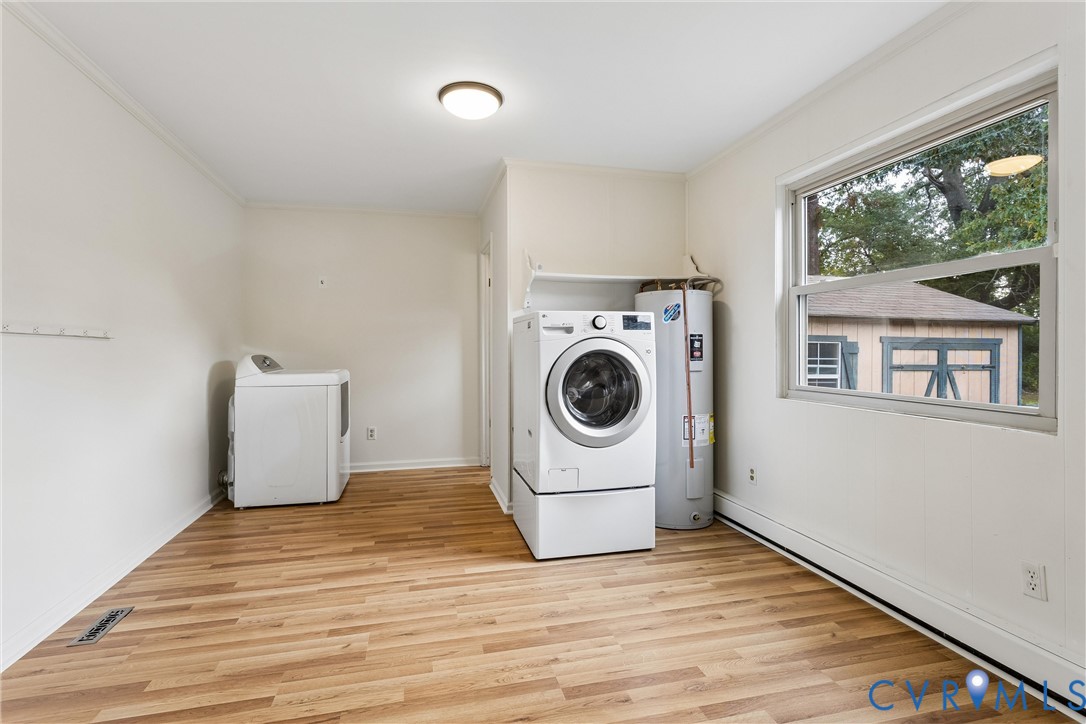Laundry area featuring wood-finish flooring, a built-in shelf, and a large horizontal window
