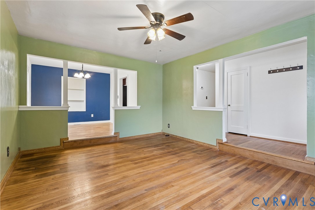 Wood-finish flooring, ceiling fan with integrated lighting, recessed wall shelving, and raised floor platforms