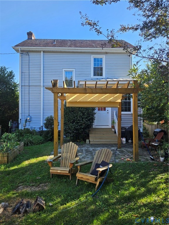 Two-story residence with light-colored siding, flagstone patio, and wooden pergola structure