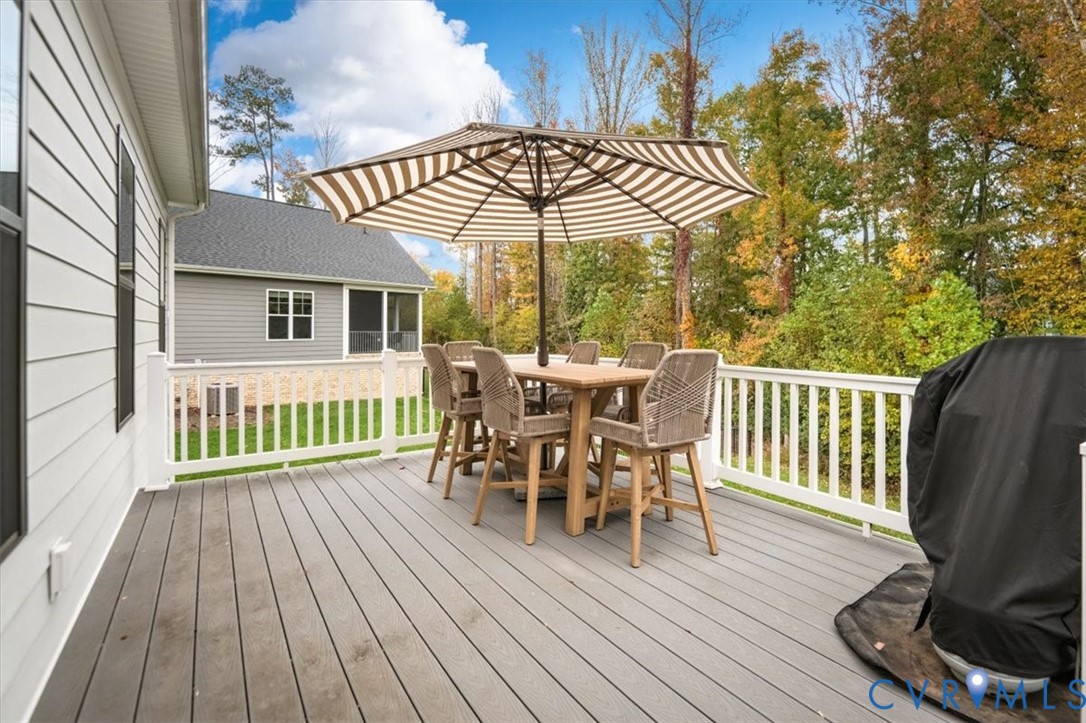 Elevated deck featuring low-maintenance composite decking, white vinyl railings, and horizontal lap siding