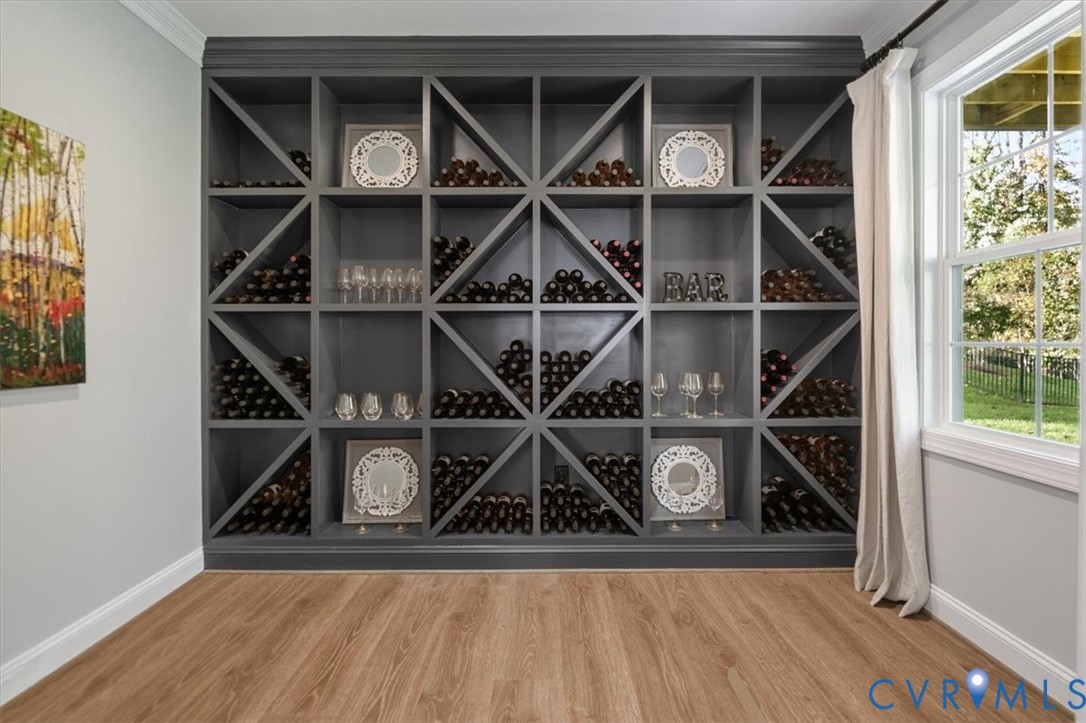 Terrace level - Floor-to-ceiling custom built-in wine storage featuring dark charcoal finish, X-pattern shelving, and wood-finish flooring