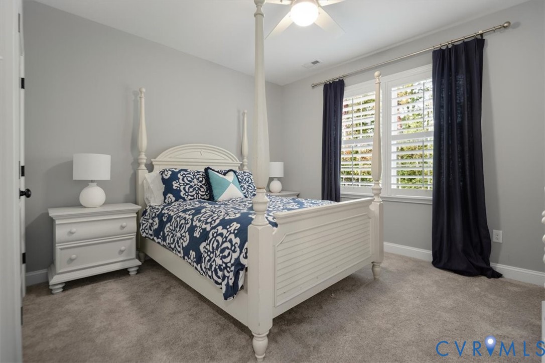 Terrace Level -Neutral-toned interior featuring wall-to-wall carpeting, white plantation shutters, and a ceiling-mounted light fixture with a fan