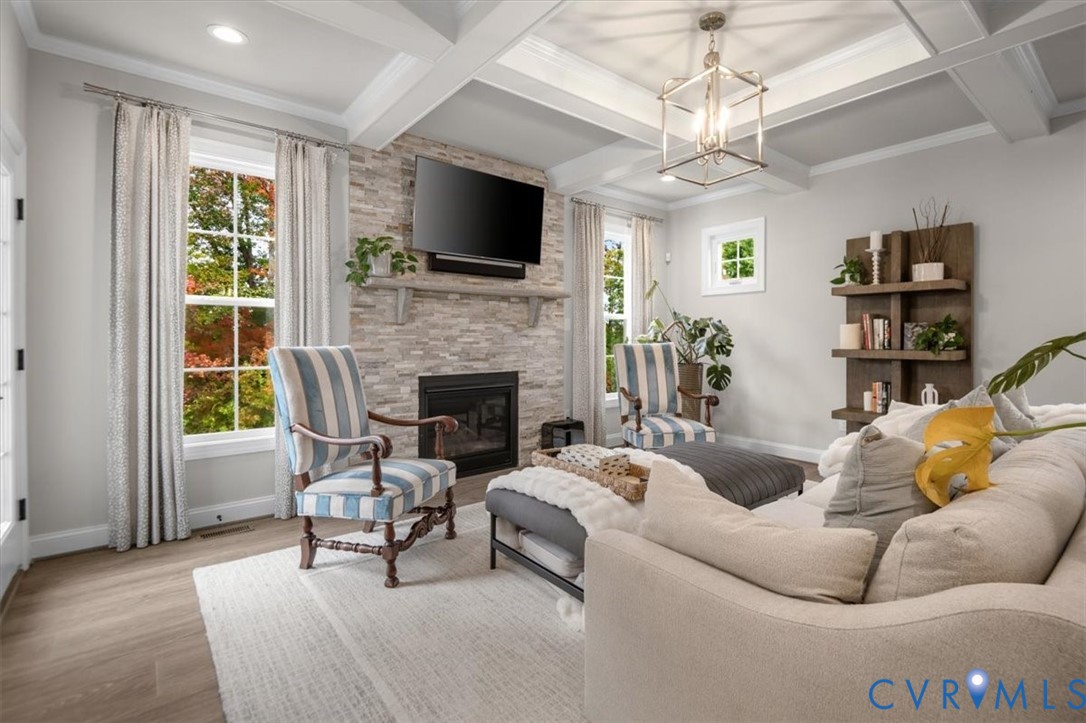 Coffered ceiling, stone-surround fireplace, built-in shelving, multi-pane windows, and wood-finish flooring