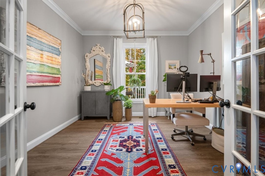 French doors with glass panes, wood-finish flooring, crown molding, and a metal lantern-style light fixture