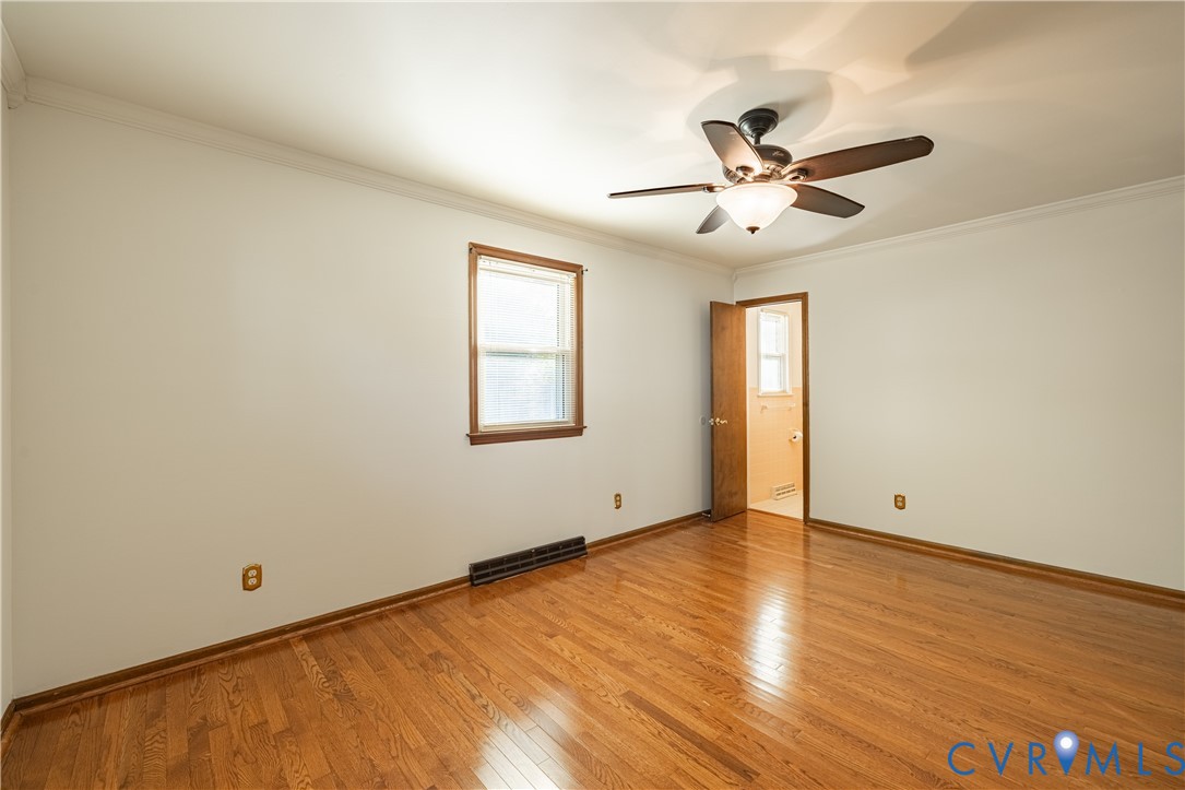Wood-finish flooring, central ceiling fan with integrated lighting, and crown molding