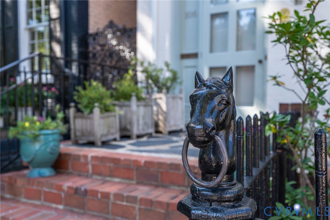 Cast-iron horse-head hitching post on the front fence.