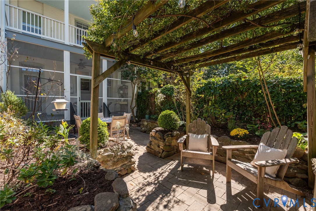 Walled courtyard garden with a pergola and stone walls. Walled courtyard garden with a pergola and stone walls.