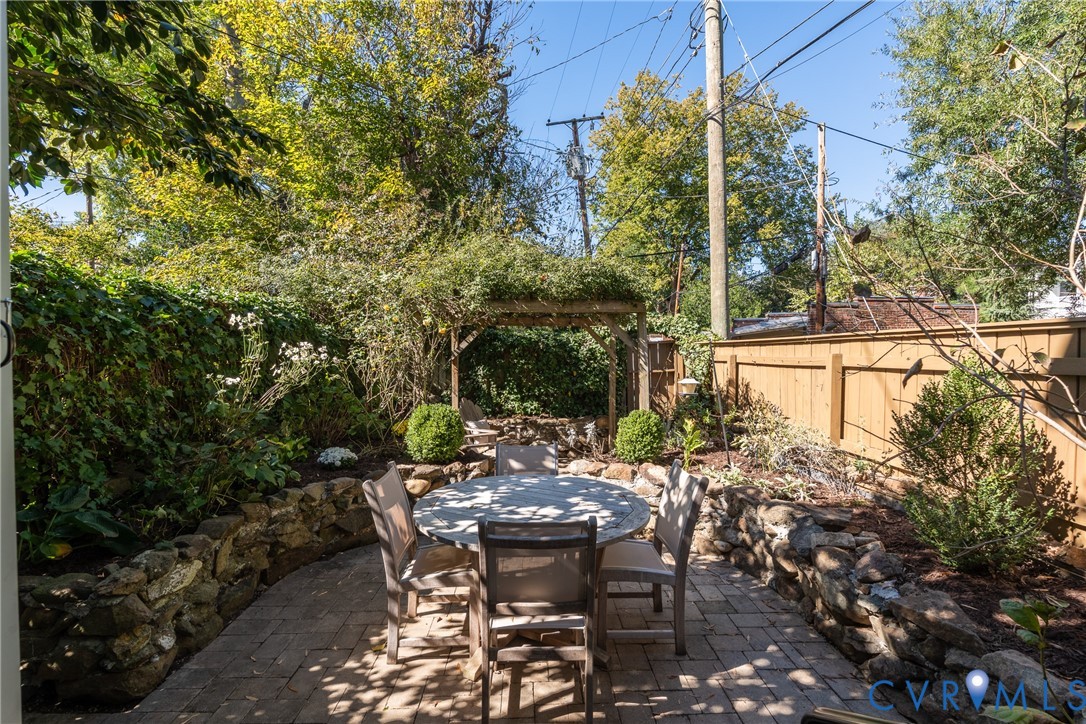 Garden dining patio with stone walls, boxwoods and drip irrigation.