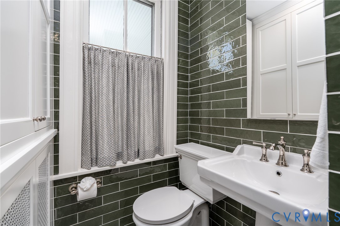 Custom built-in storage cabinet beside the pedestal sink.
