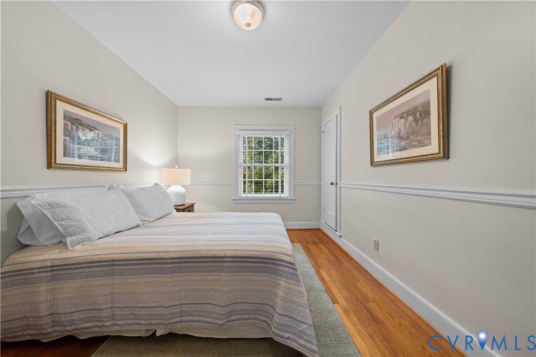 Room featuring wood-finish flooring, chair rail molding, multi-pane window, and flush-mount ceiling lighting