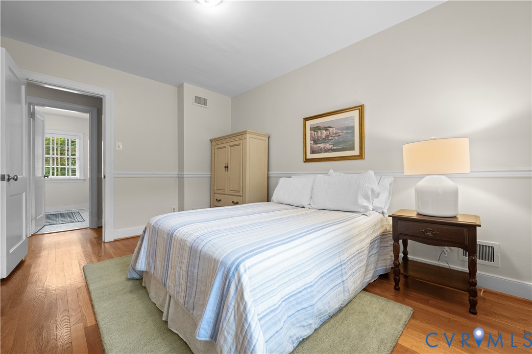 Interior space featuring wood-finish flooring, chair rail molding, and multi-pane window glazing