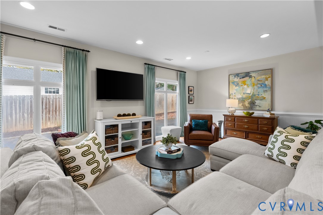 Living area featuring recessed lighting, chair rail molding, and dual glass-paned doors