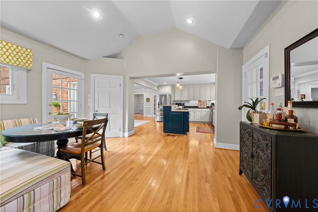 Vaulted ceilings, wood-finish flooring, recessed lighting, glass-paneled exterior door, and kitchen with center island
