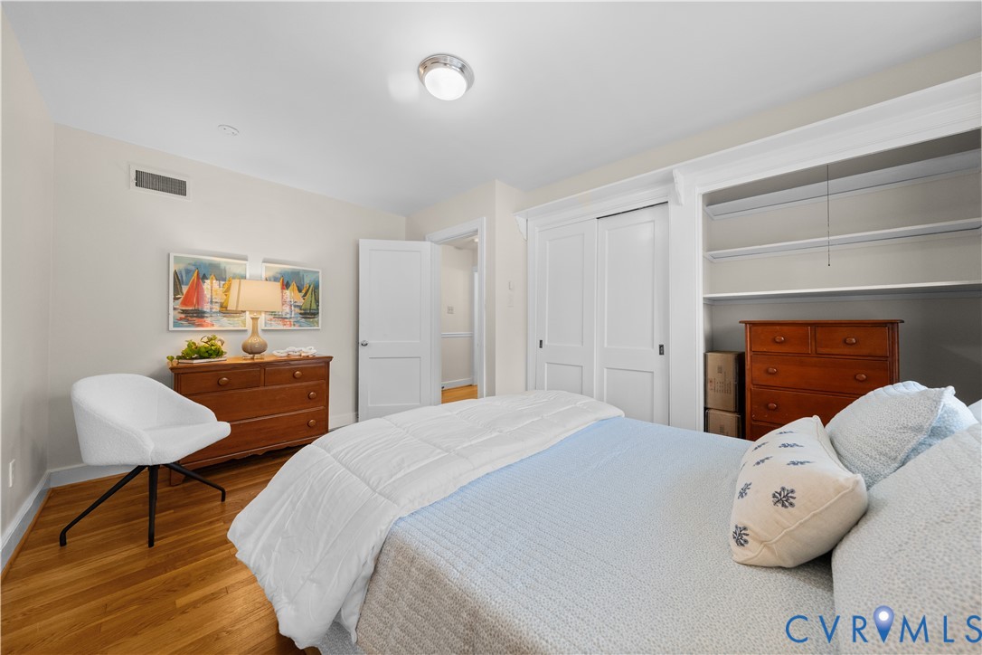 Wood-finish flooring, white paneled doors, built-in shelving, and closet storage with custom millwork