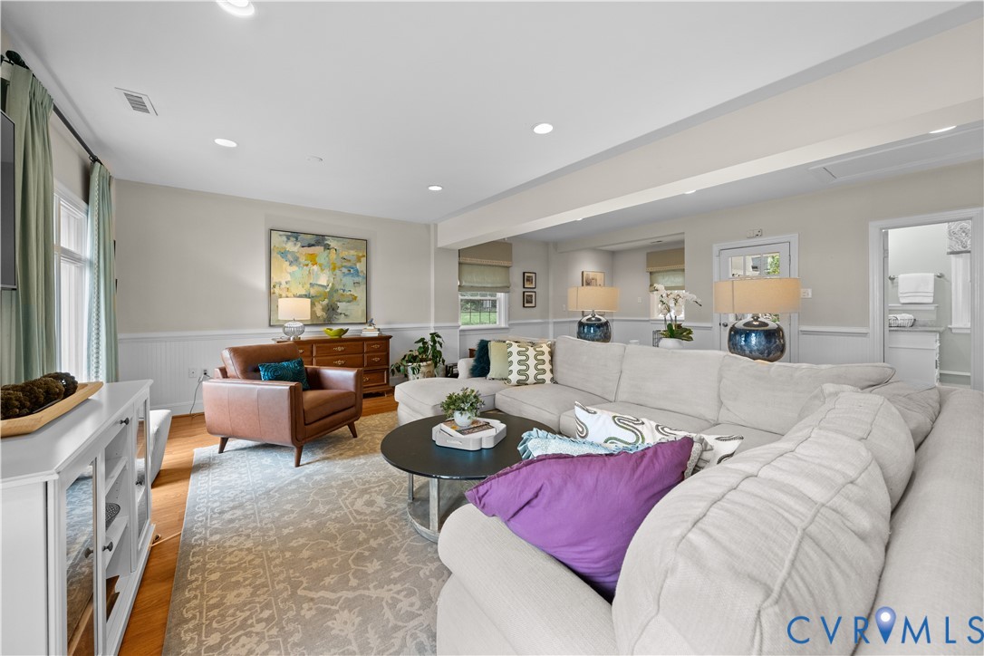 Living area featuring wood-finish flooring, white wainscoting, recessed lighting, and a neutral wall color palette