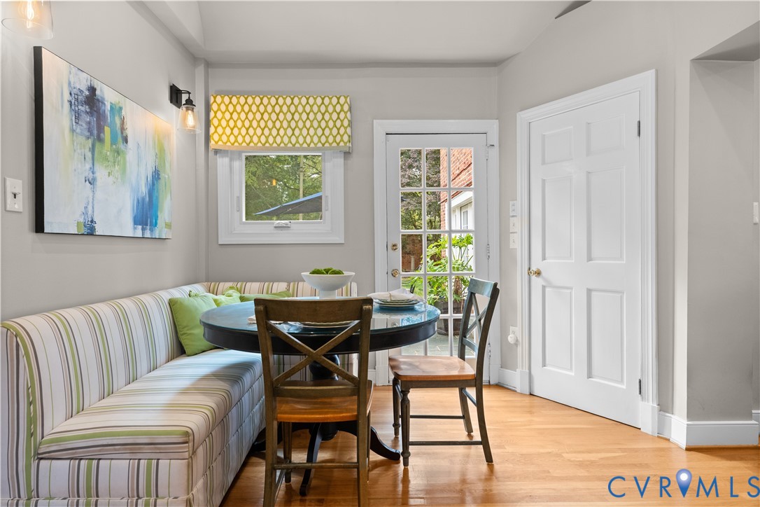 Built-in corner bench seating, wood-finish flooring, six-panel interior door, and a glass-paneled exterior door
