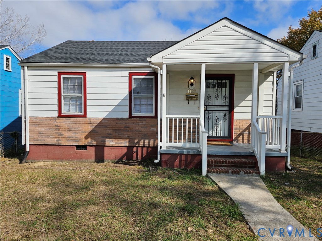 Exterior featuring partial brick facade, horizontal siding, and a covered front porch with white railing