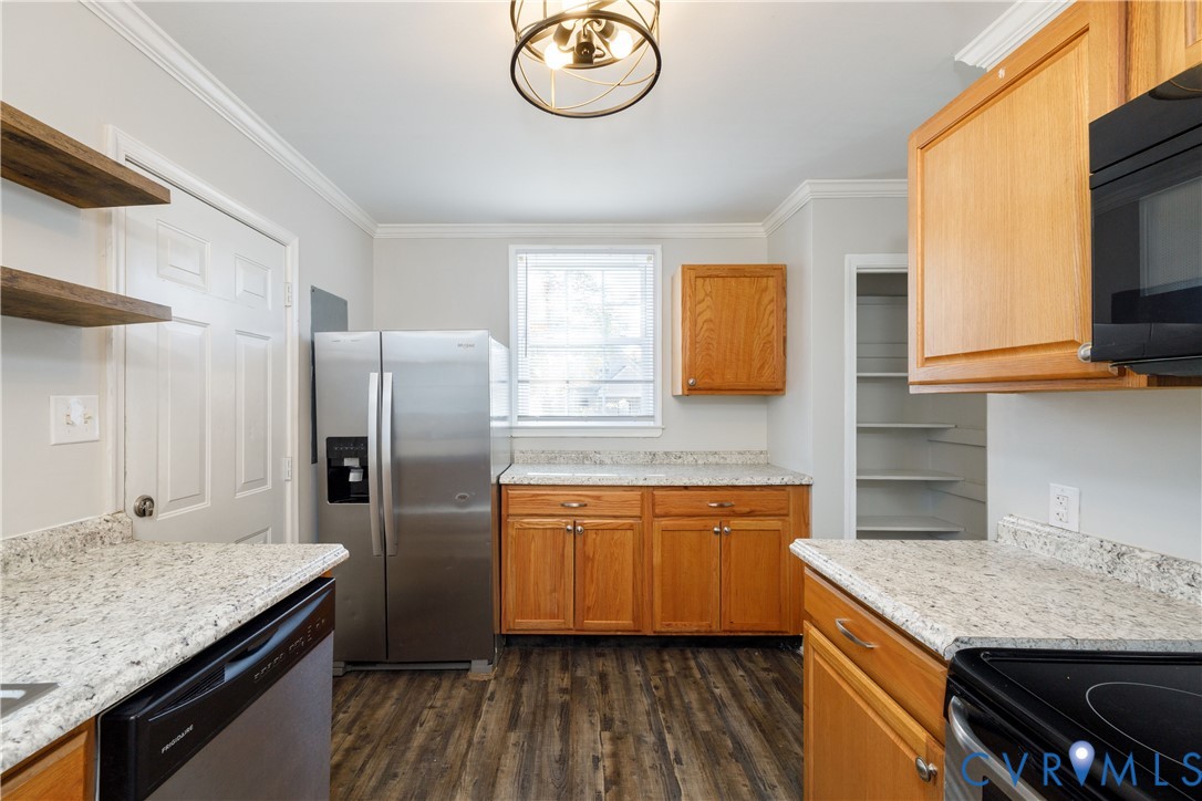 Kitchen featuring natural wood cabinetry, stone-patterned countertops, wood-finish flooring, stainless steel appliances, and a built-in pantry with shelving Kitchen featuring natural wood cabinetry, stone-patterned countertops, wood-finish flooring, stainless steel appliances, and a built-in pantry with shelving