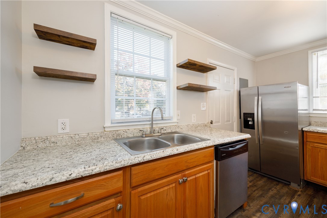 Kitchen featuring stone-finish countertops, stainless steel appliances, wood-finish cabinetry, wood-finish flooring, and wall-mounted wooden shelving Kitchen featuring stone-finish countertops, stainless steel appliances, wood-finish cabinetry, wood-finish flooring, and wall-mounted wooden shelving