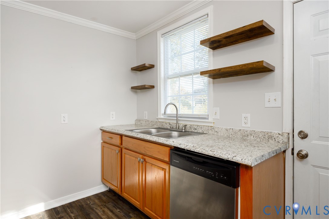 Natural wood-finish cabinetry, stone-texture laminate countertop, dual-basin stainless steel sink, built-in stainless steel dishwasher, and mounted wood shelving Natural wood-finish cabinetry, stone-texture laminate countertop, dual-basin stainless steel sink, built-in stainless steel dishwasher, and mounted wood shelving
