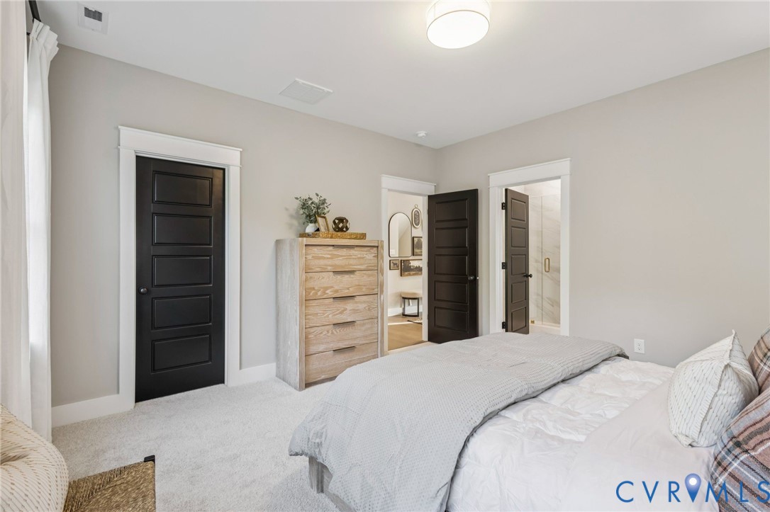 Light-toned walls with contrasting dark paneled doors and white trim, featuring soft carpet flooring