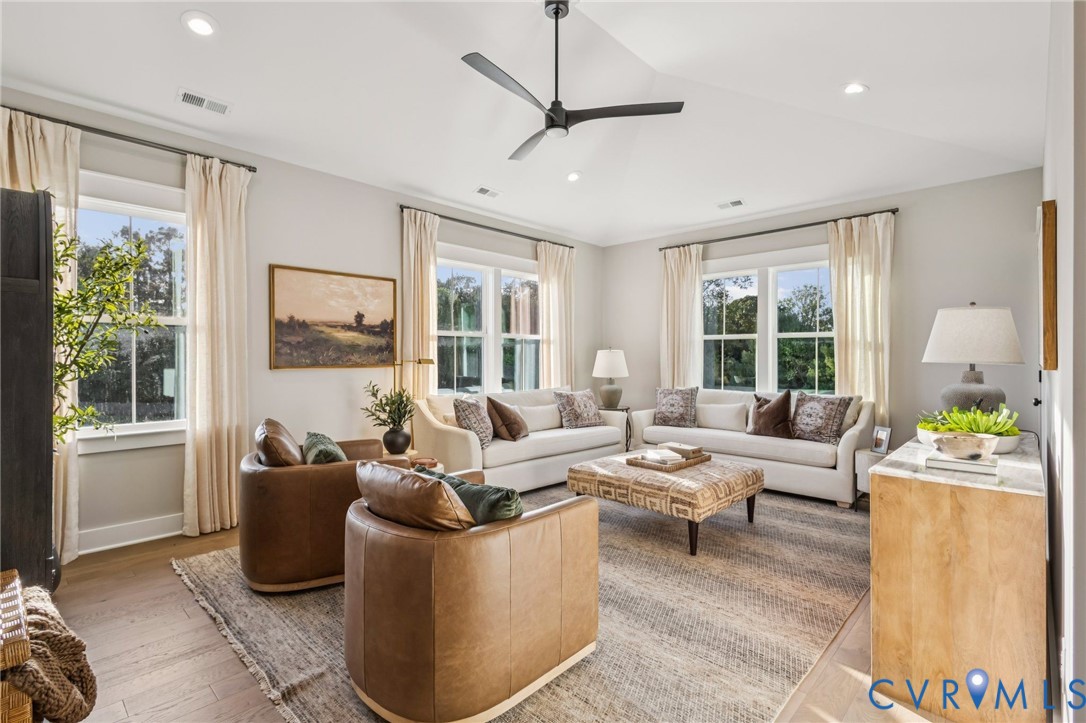 Spacious living area featuring wood-finish flooring, recessed lighting, and a modern ceiling fan
