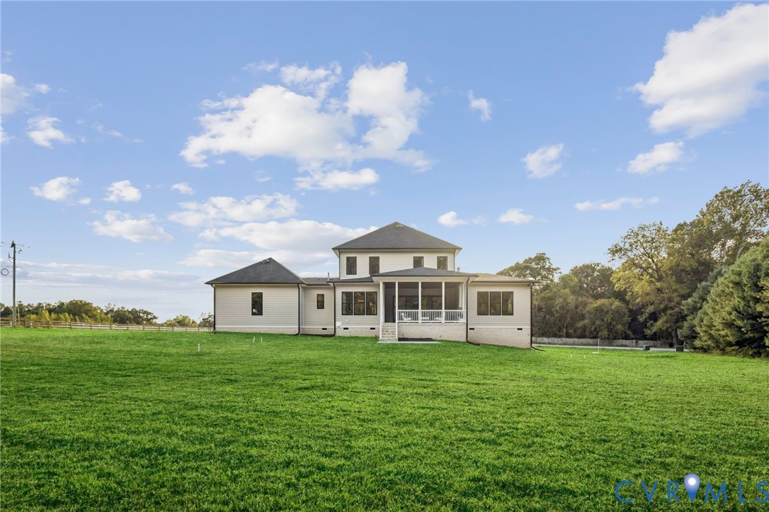 Expansive green lawn surrounds a contemporary home featuring light-colored siding, a screened porch, and a multi-level roofline