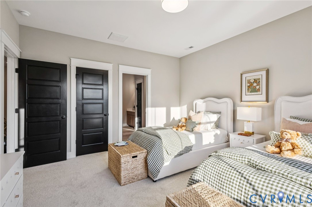 Bedroom featuring light-colored walls, carpeted flooring, and a flush-mount ceiling light fixture