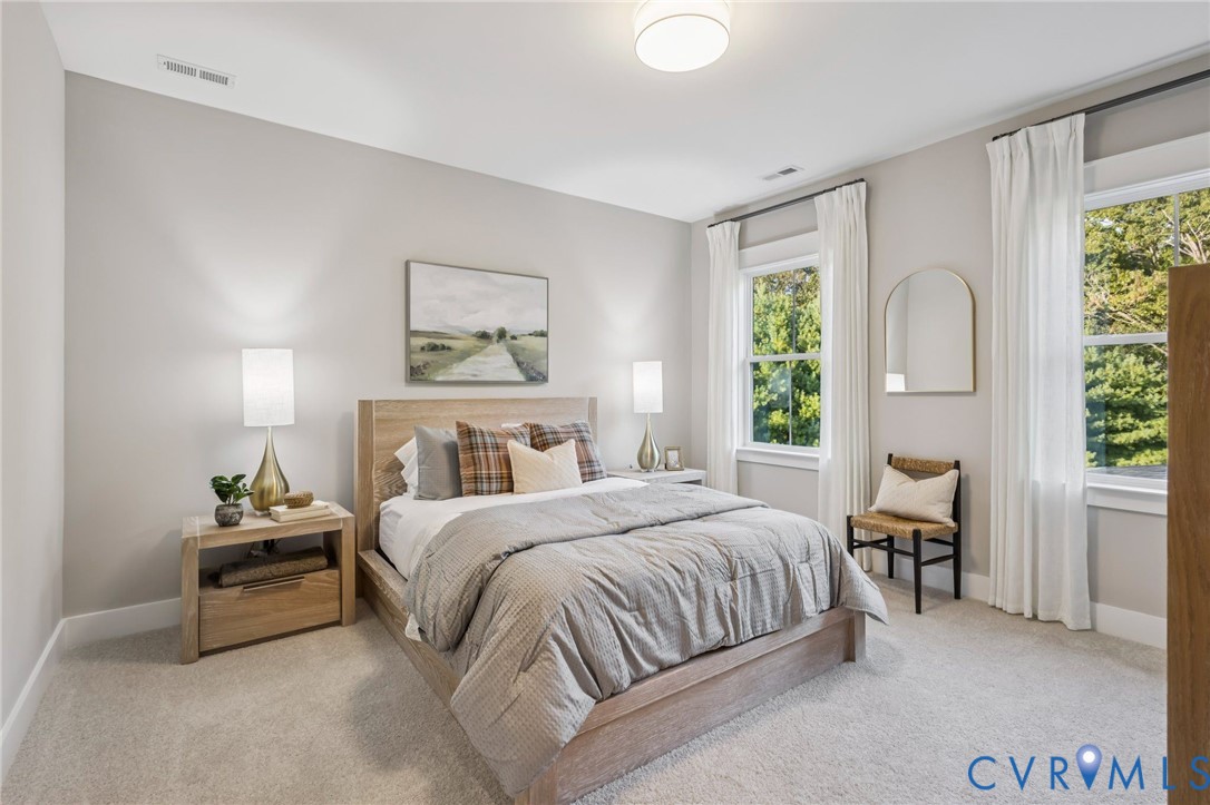 Bedroom featuring neutral wall paint, light-toned carpet, a contemporary bed frame, and two large windows