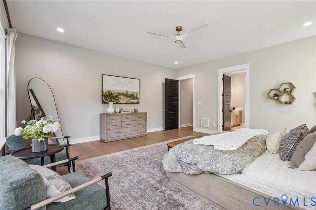 Spacious room featuring wood-finish flooring, recessed lighting, and a contemporary ceiling fan