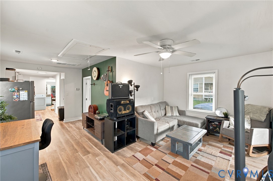 Wood-finish flooring, ceiling fan with integrated lighting, and accent wall