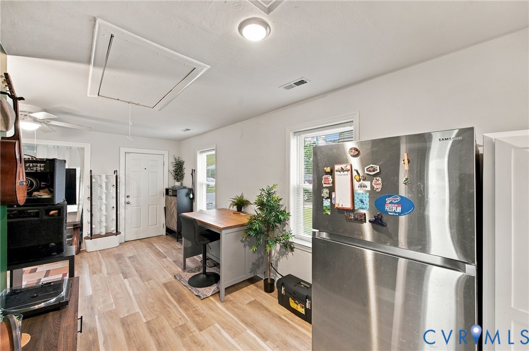 Interior space featuring light-toned wood-finish flooring, dual windows with white trim, and a ceiling-mounted flush light fixture