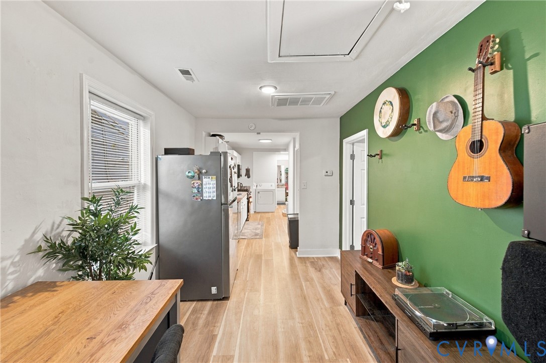 Interior space featuring wood-finish flooring, a single-hung window with blinds, and recessed lighting
