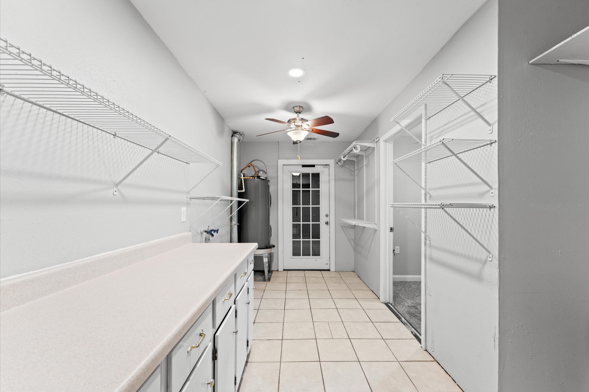 Near the front entry to the home is this large space that includes the laundry room, extra storage, a 2023 water heater, and access to a flex space or 4th bedroom.