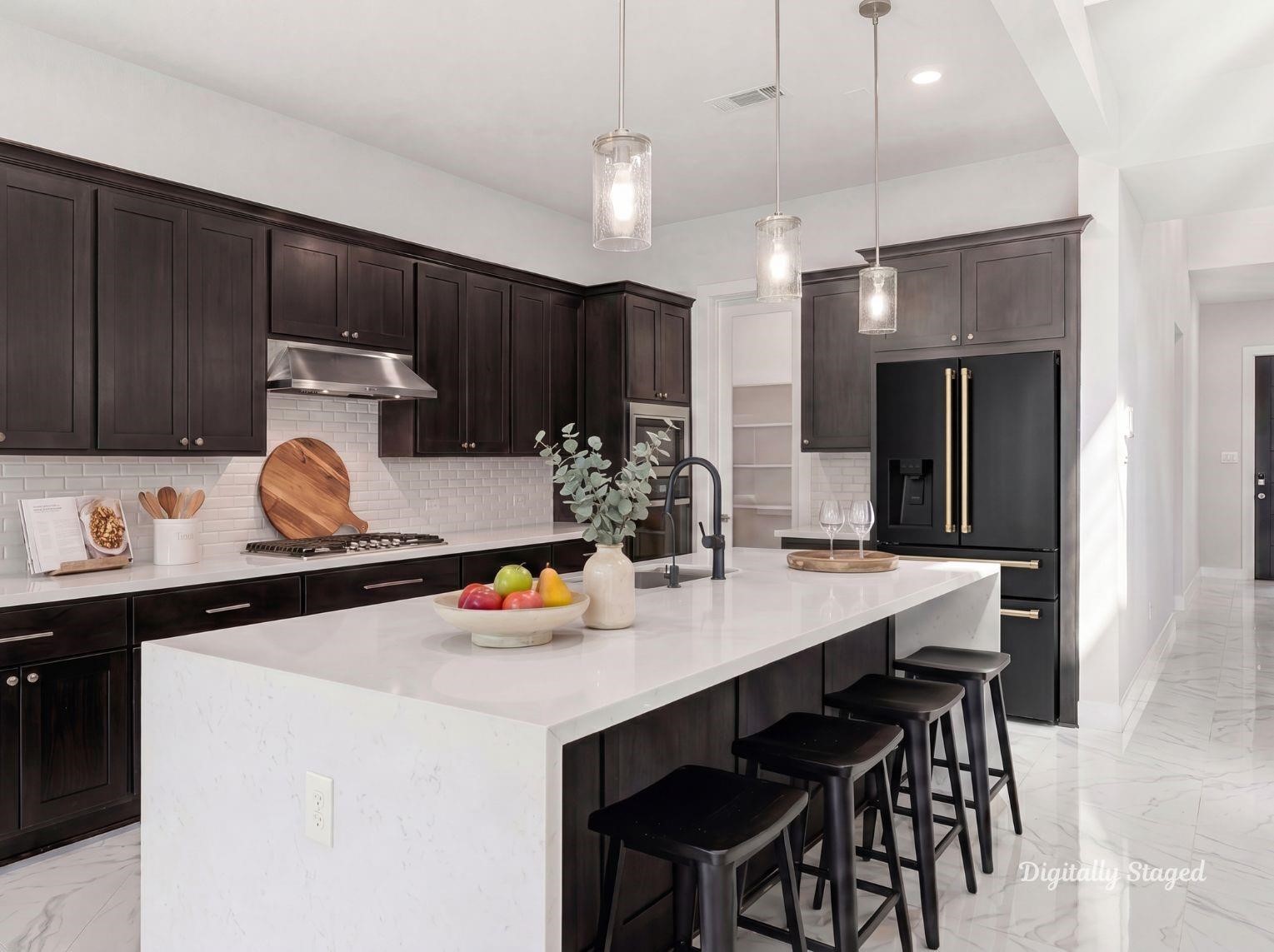 A modern chef's kitchen boasting an
oversized island with a breakfast bar,
sleek dark cabinetry, white subway
tile backsplash, and stainless steel
appliances. This photo has been
digitally staged to illustrate the
possibilities of the homes aesthetic
and potential design. Some
furnishings and dcor shown are for
visual inspiration.