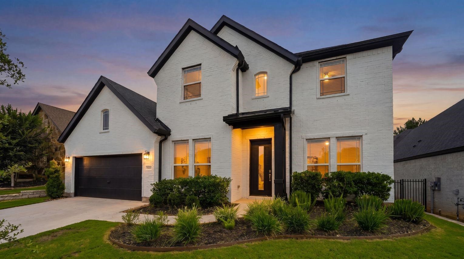 Stunning twilight view of this modern
two-story home, showcasing a
striking painted white brick exterior, a
dark- trimmed roofline, professional
landscaping, and a three-car garage.
This photo has been digitally staged
to illustrate the possibilities of the
homes aesthetic and potential
design. Some furnishings and dcor
shown are for visual inspiration.