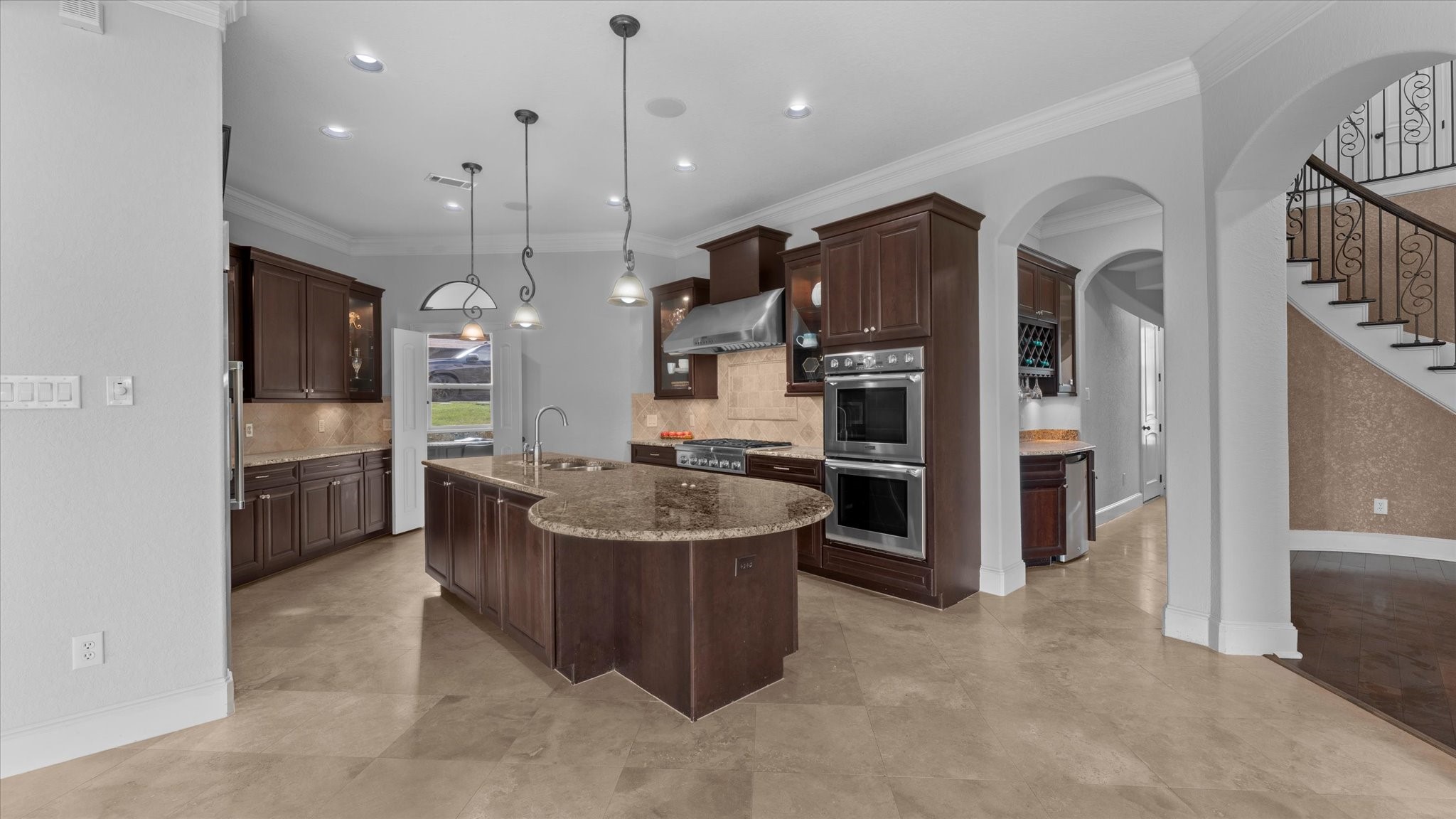 Chef inspired kitchen with Thermador appliances and double ovens.  Through the doors straight ahead is the walk-in pantry.