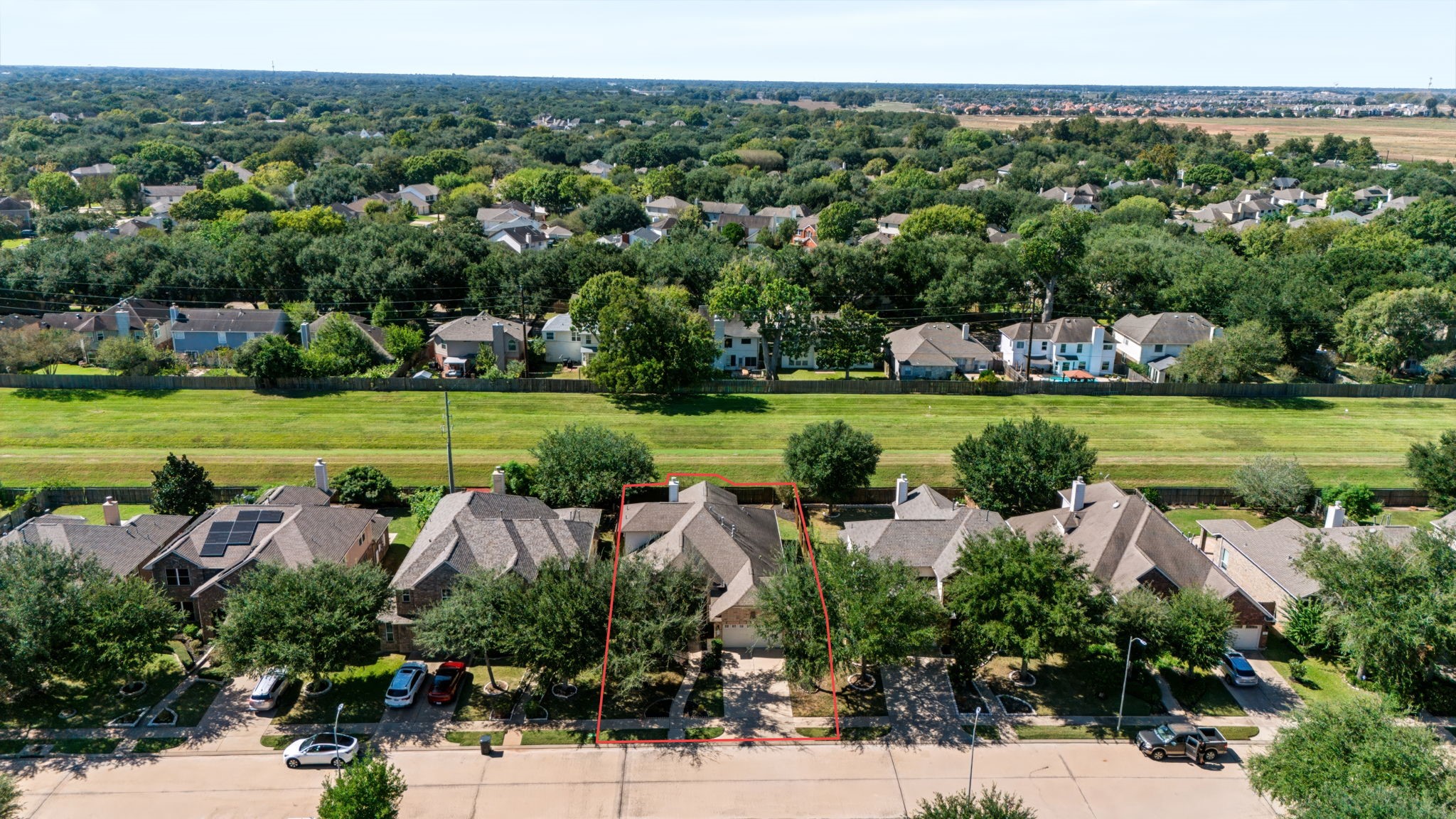 Bird's-eye view highlighting the green space behind the home.