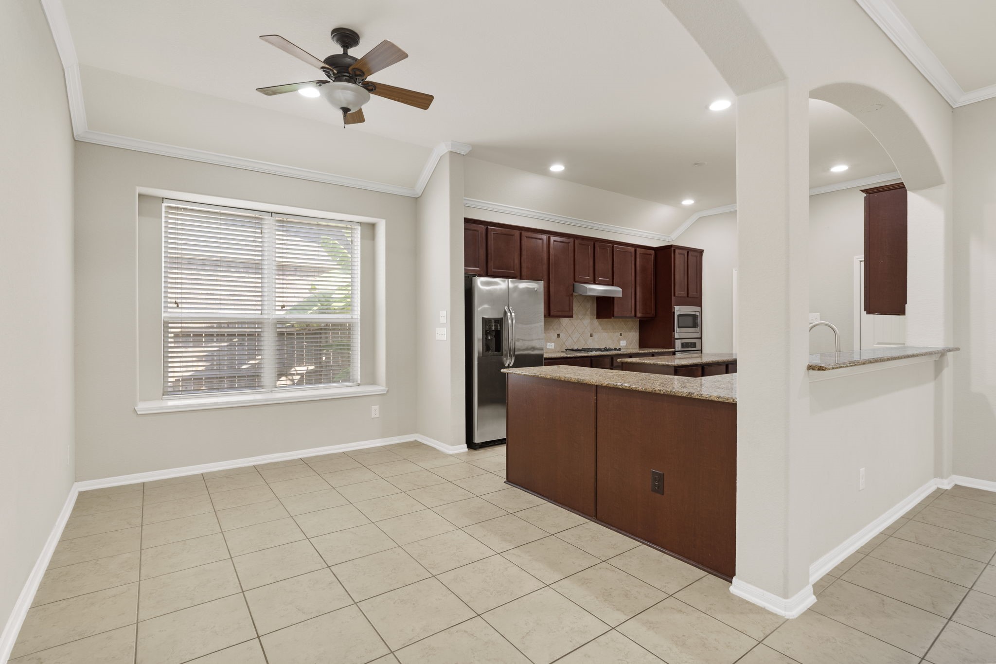 Enjoy morning coffee or casual meals in the sunlit breakfast area, where a large window brings in natural light and creates a warm, inviting atmosphere.
