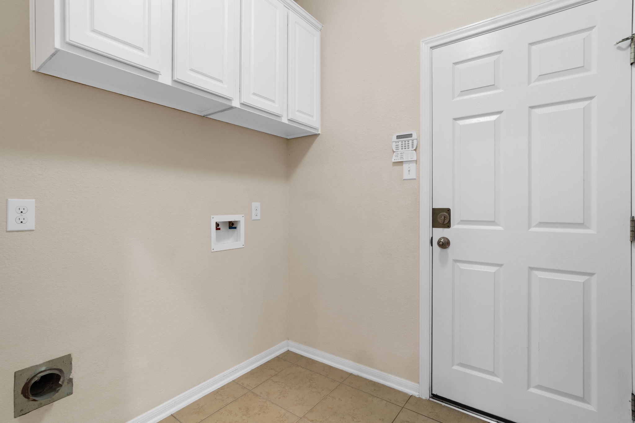 First floor in-home laundry room with built-in storage cabinets and direct access to the attached garage.