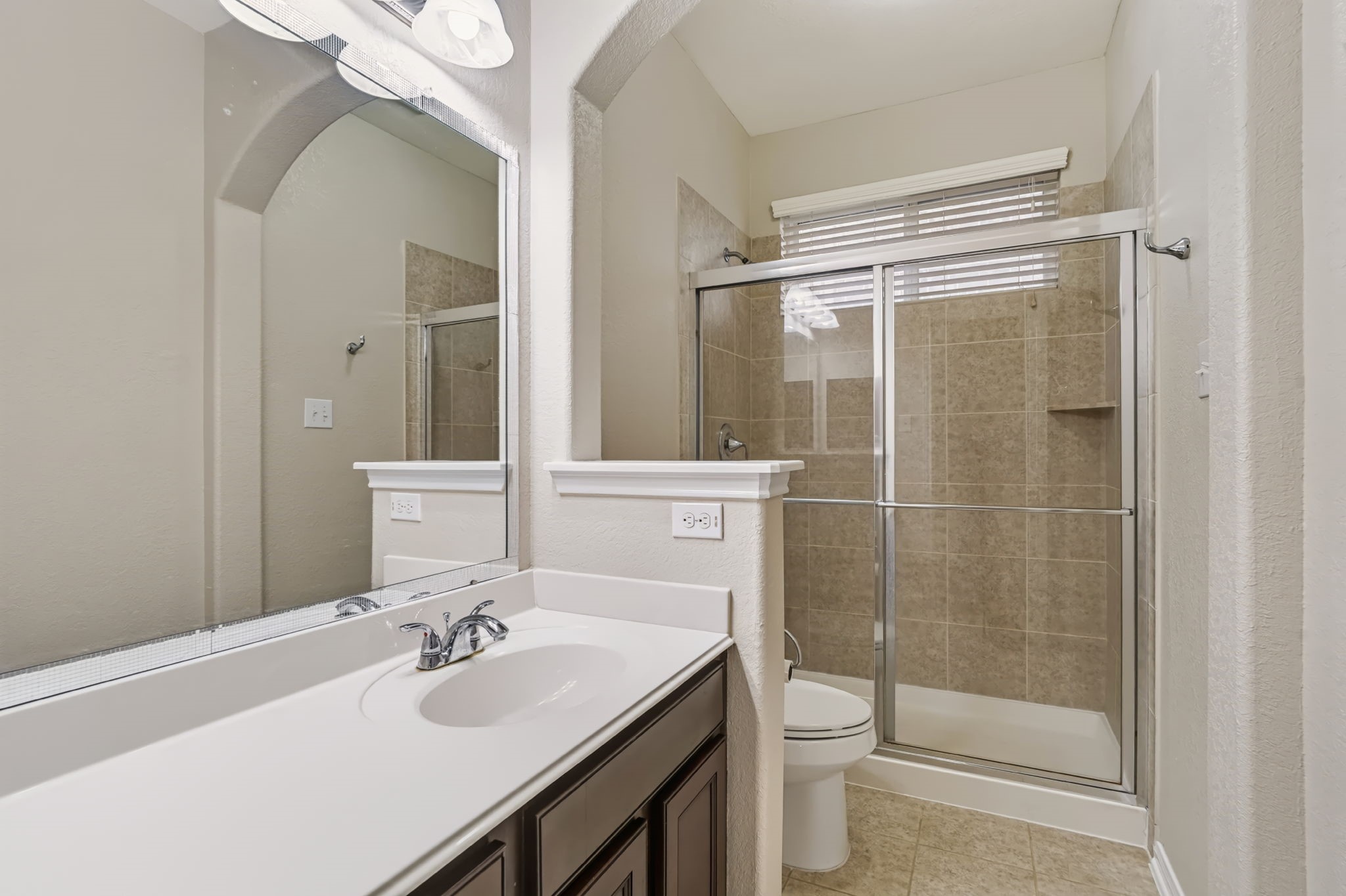Full bathroom with walk-in shower and large vanity featuring extended counter space.