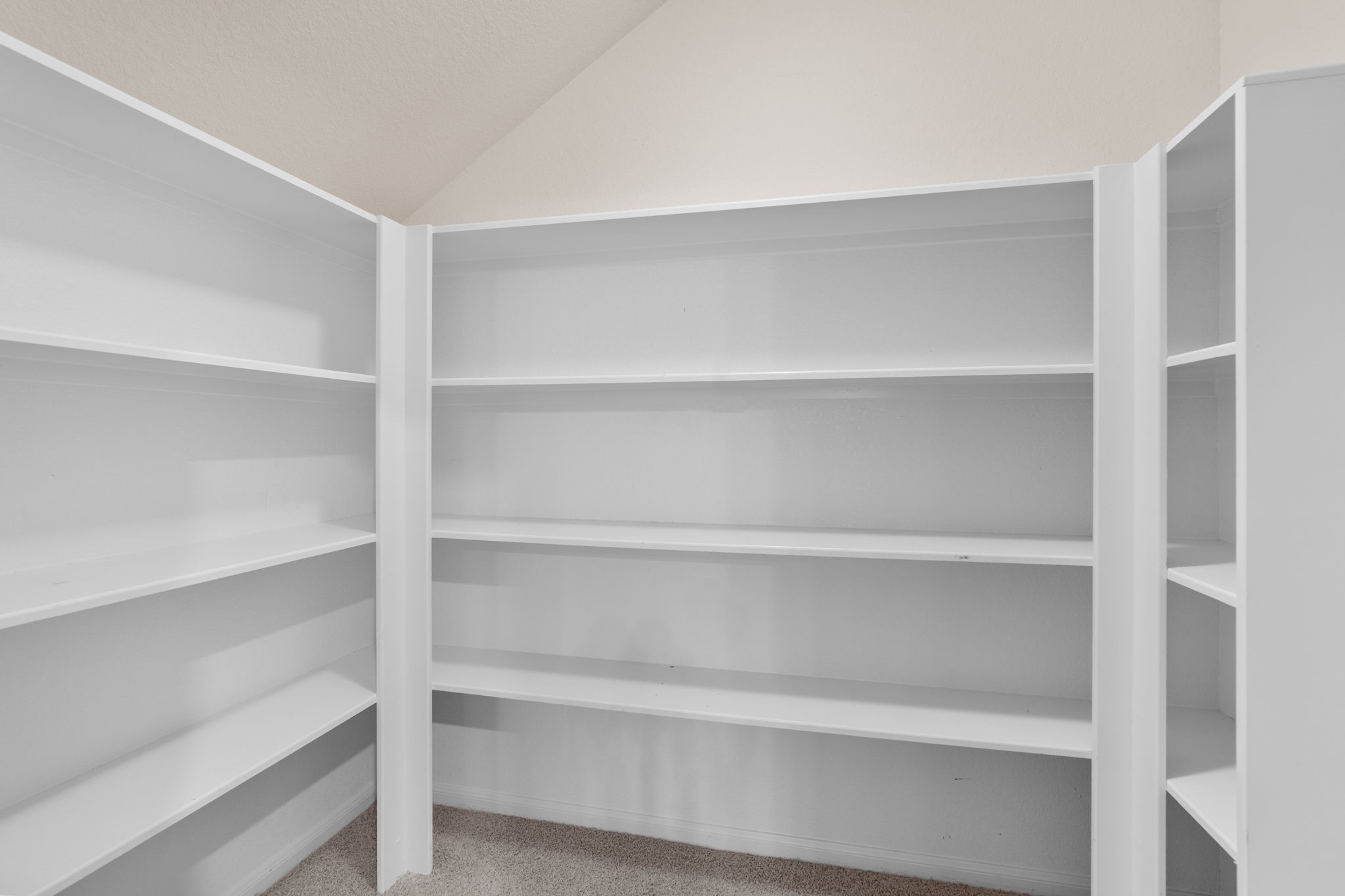 Game room walk-in closet with ample built-in shelving for organized storage.