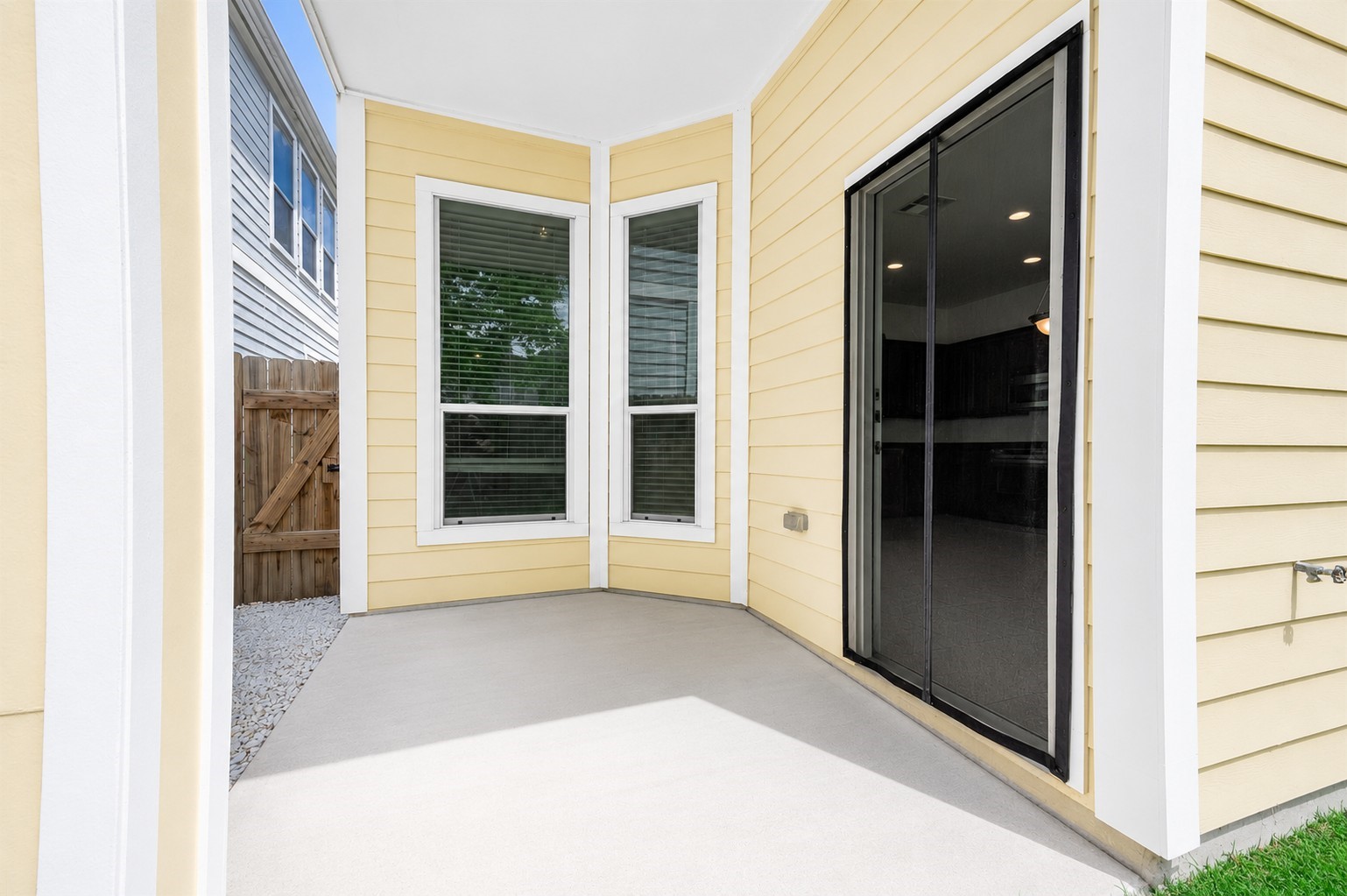 This covered patio area allows access into the home interiors through a sliding glass door. 2 large windows provide interiors with natural light. Virtually staged to inspire design possibilities