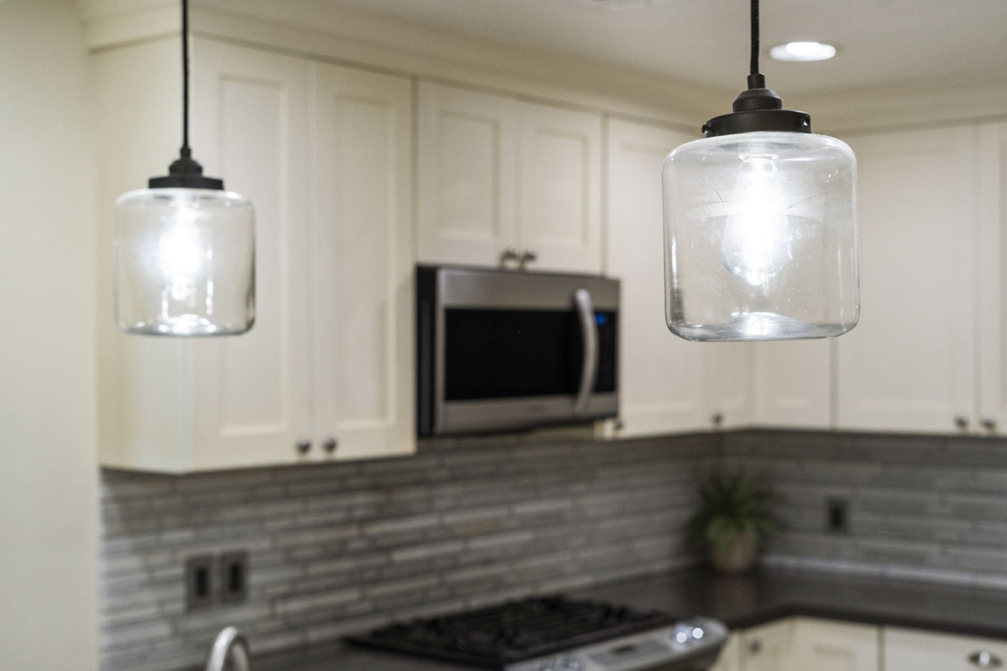 Glass pendant lighting adds a modern touch above the breakfast bar.