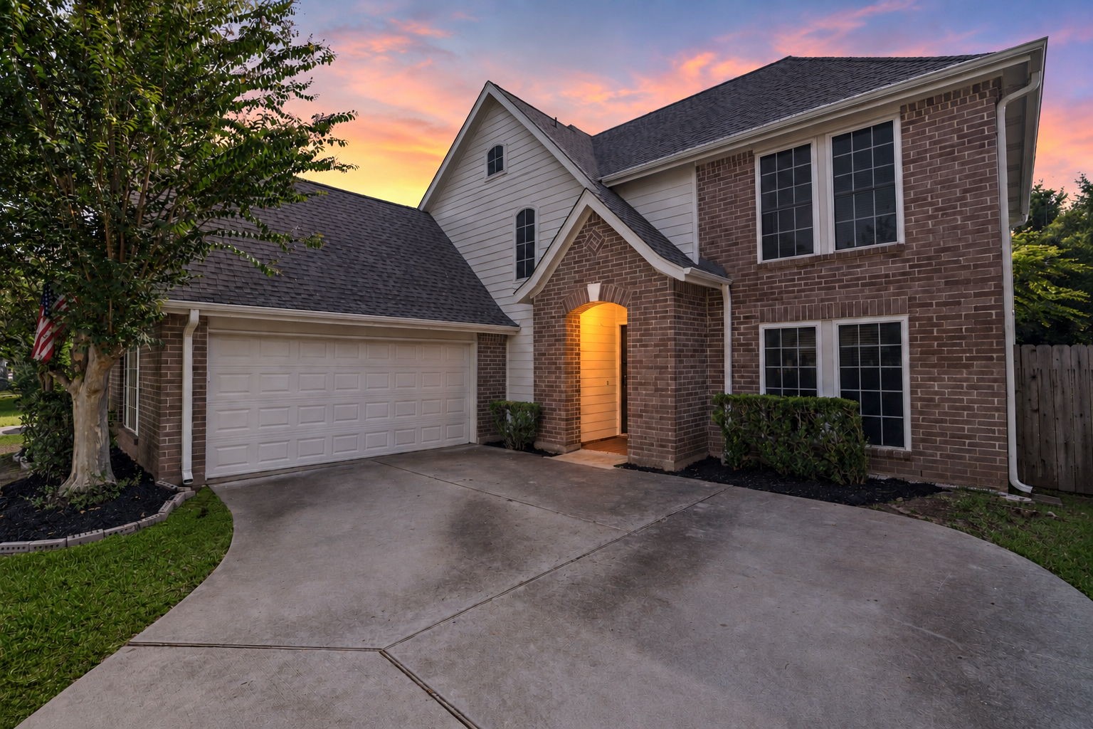 Two-car garage with an extended driveway offering plenty of additional parking space.