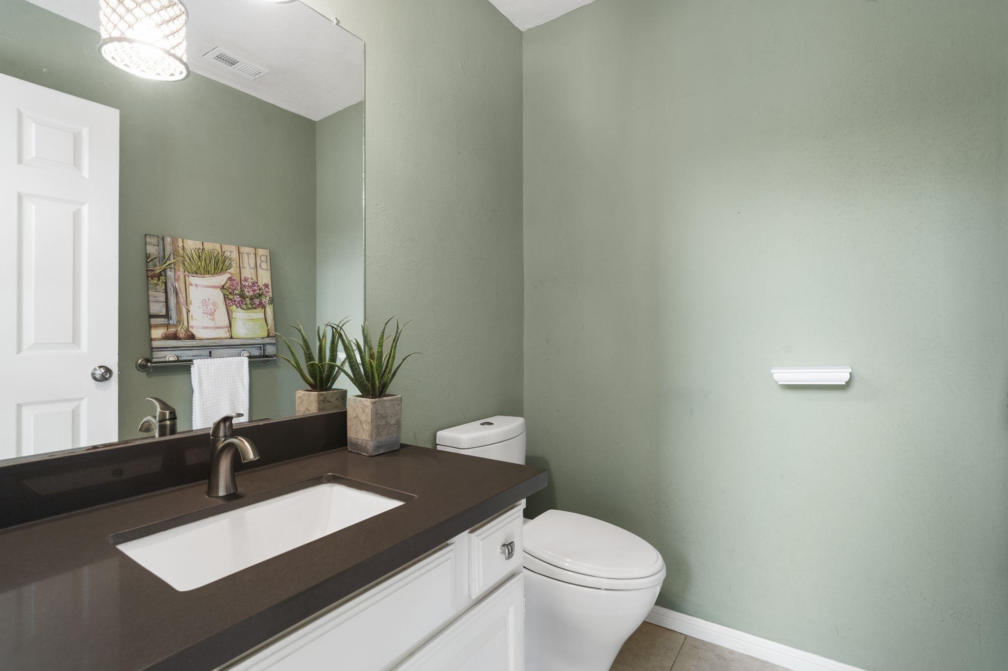 Convenient half bath with a sleek vanity & modern finishes.